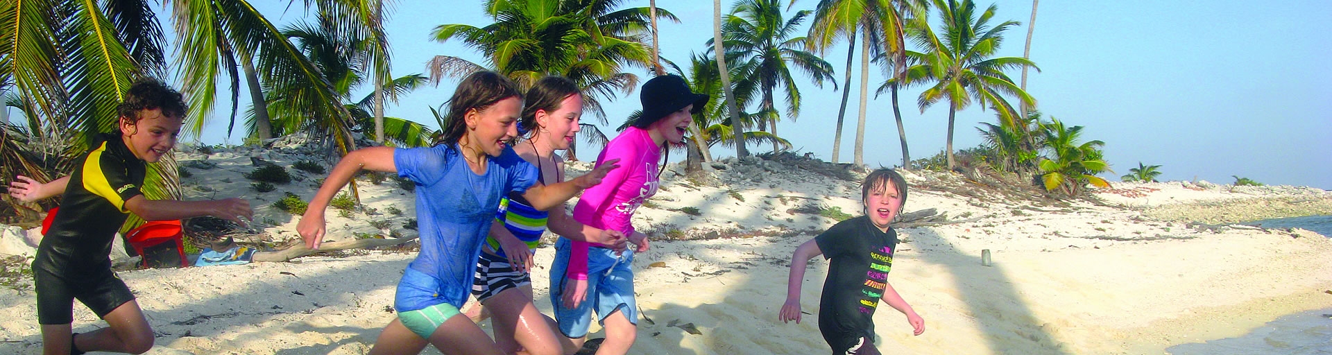 kids running on the beach in belize