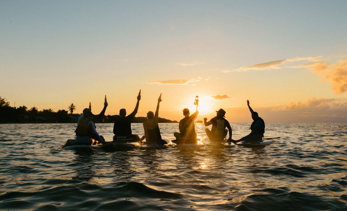 group cheer paddle board during sunset