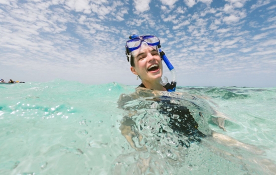 Woman enjoying snorkeling in Belize clear waters
