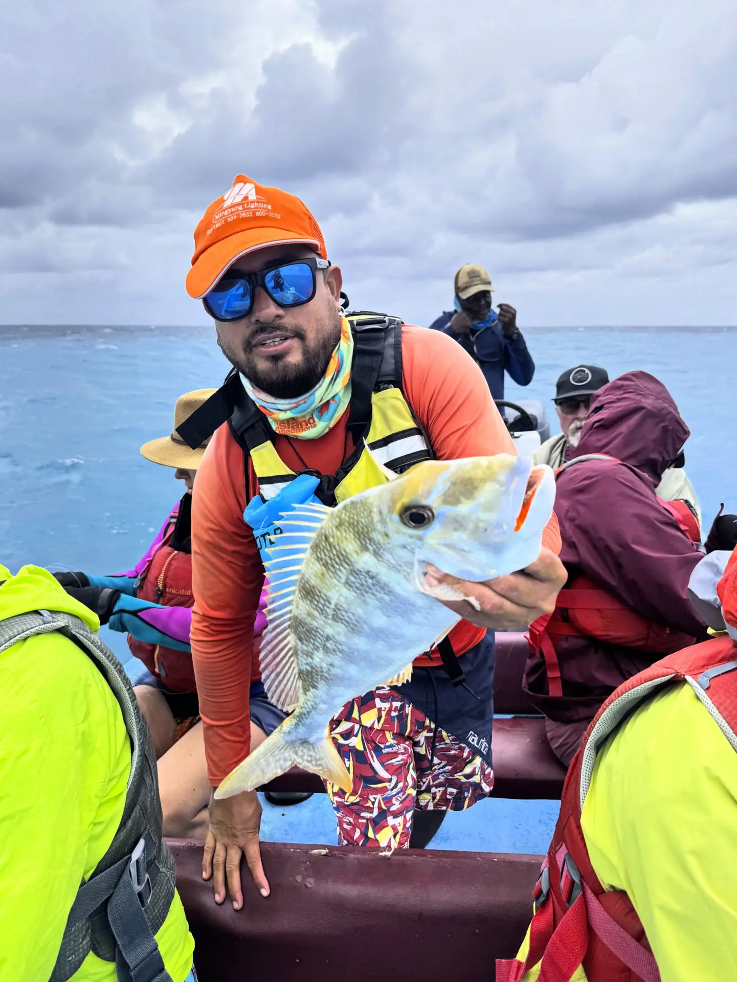 Guide in Belize holding a small fish after cultural hand-line fishing