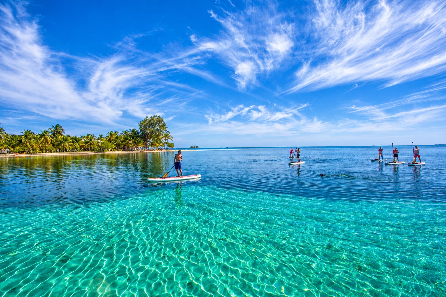 people paddle boarding on calm Caribbean waters in Belize