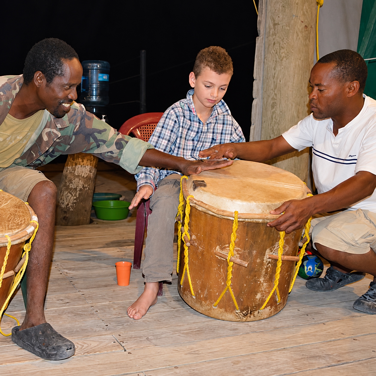 young boy learning how to play traditional drums in Belize