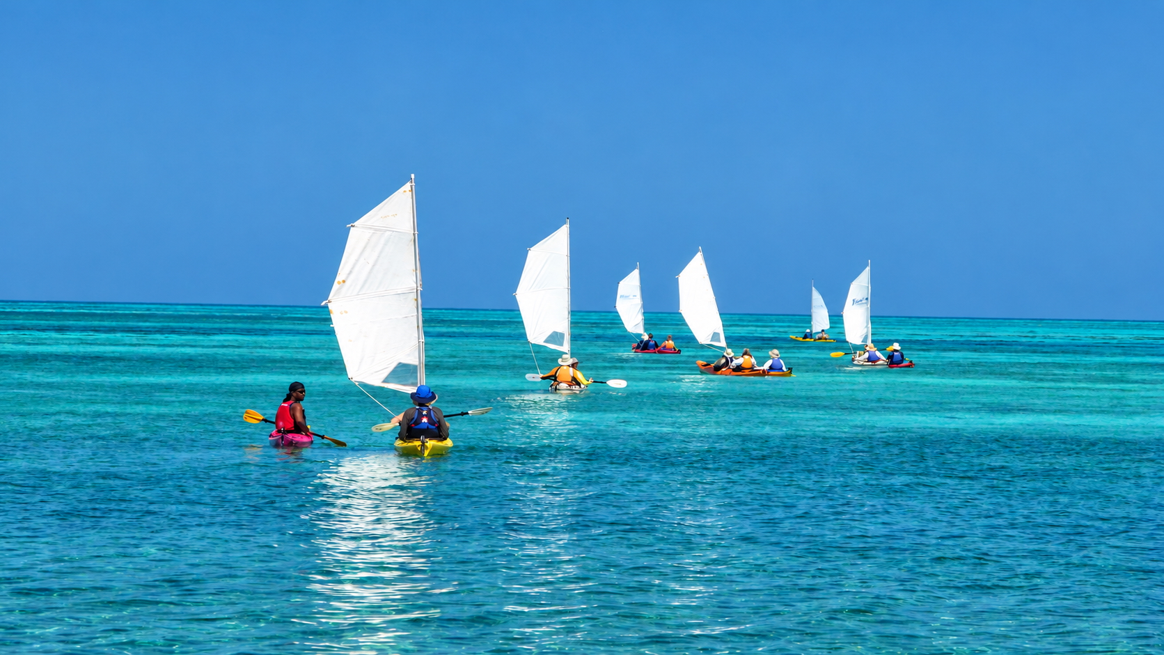 A group of travellers sailing kayaks in Belize