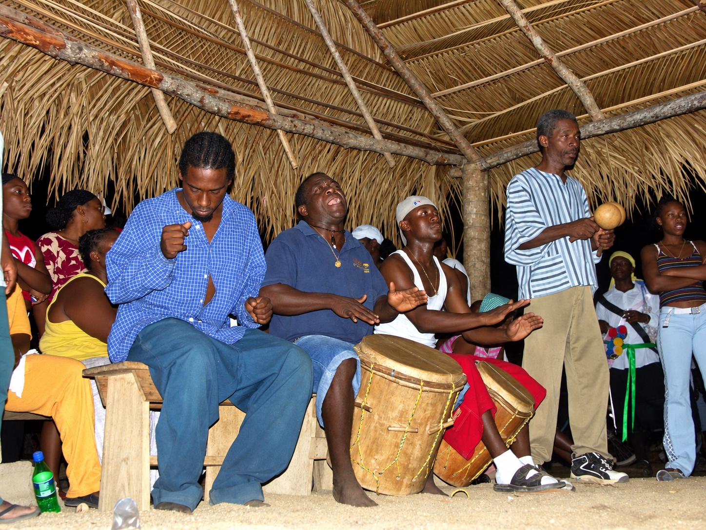 traditional Garifuna drummers performing under a thatch roof