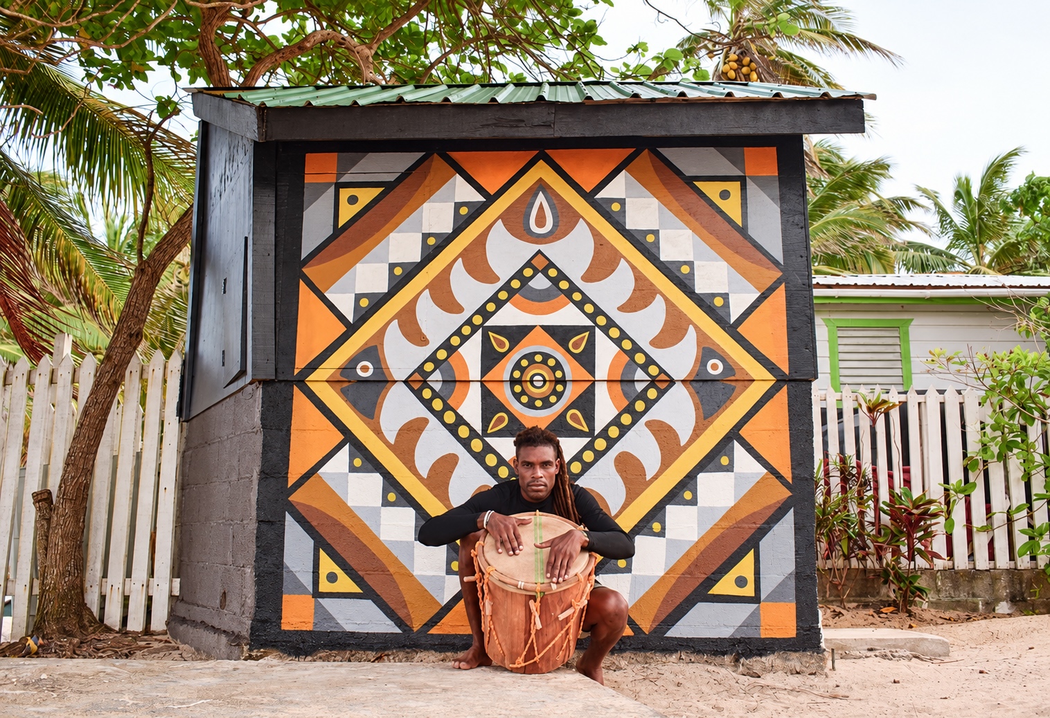 Garifuna Drummer in Belize posing in front of a mural