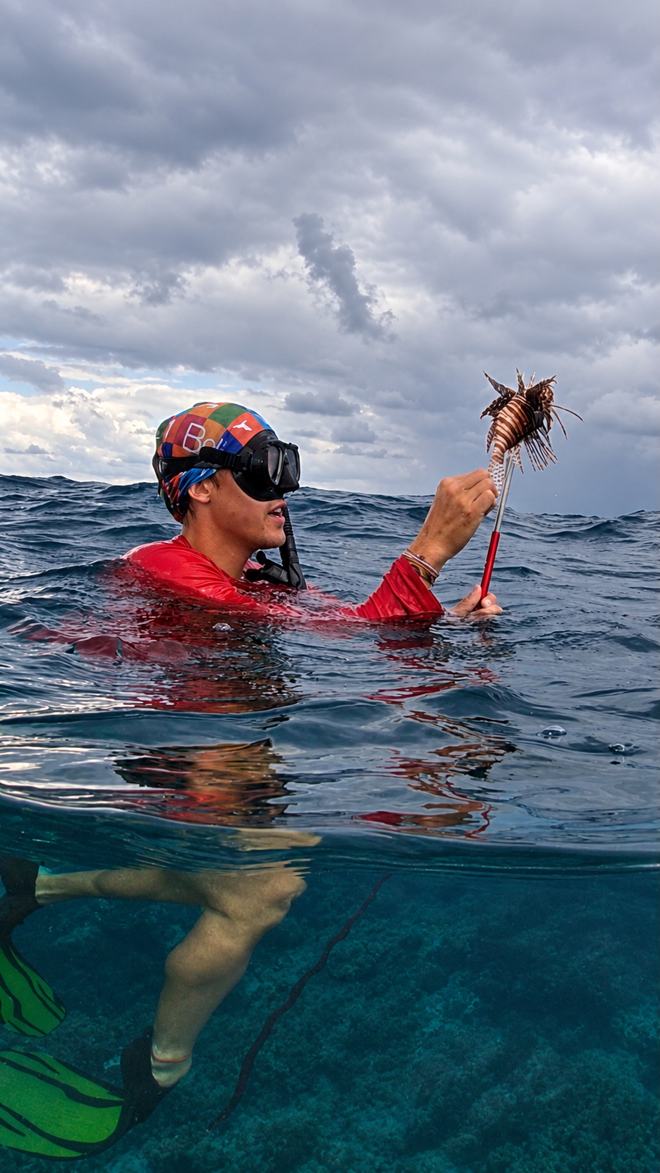 guide poses with freshly caught Lionfish