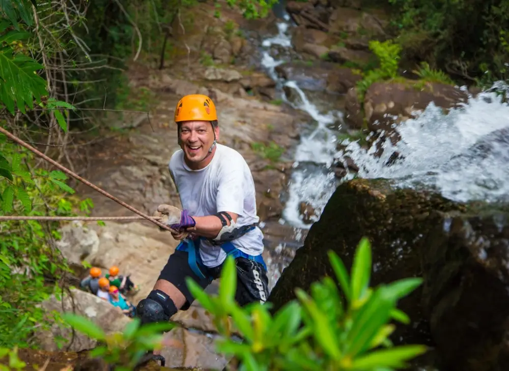 adventurer going down a waterfall in Belize