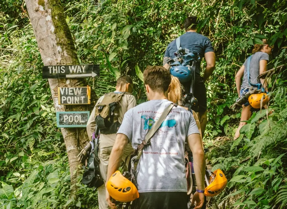 people hiking to the top of a waterfall in the jungle of Belize